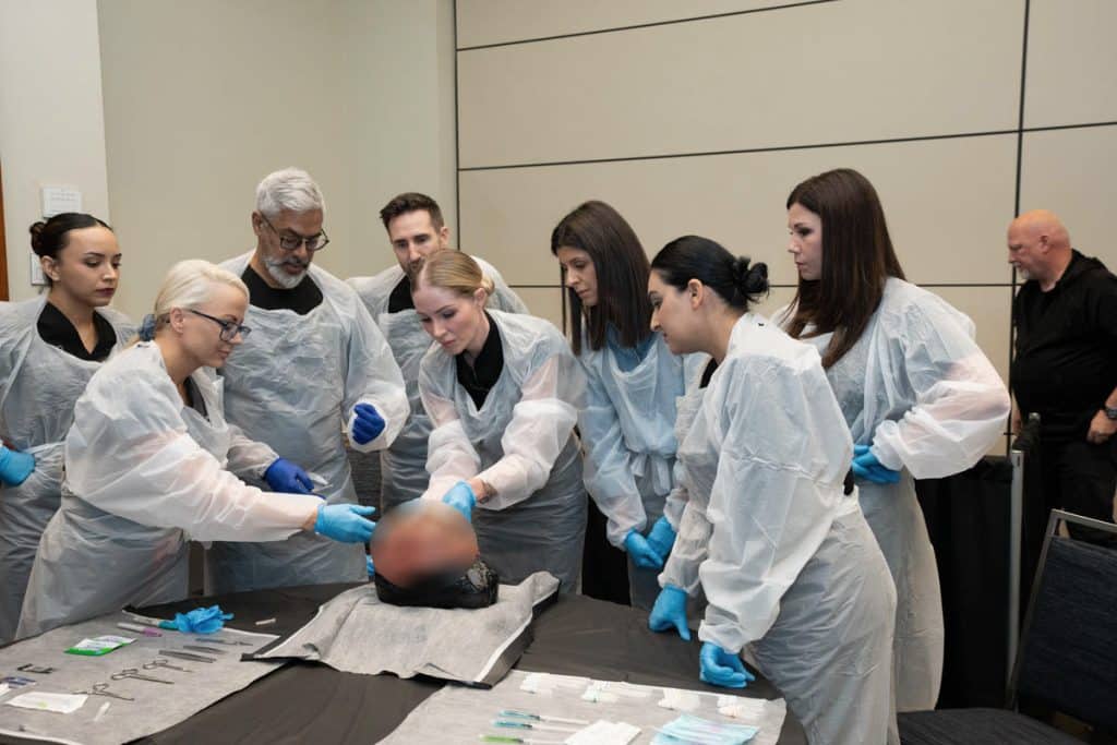 Attendees of the cadaver dissection training being shown techniques